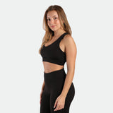 a fit woman stand at right and wearing matching set black ,bra and legging 
