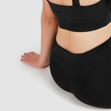 a  back view for woman wearing  matching bra and legging , she sitting one the ground ,plus logo