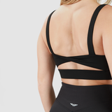  a back view for woman wearing bra with specials  design  and wearing a short it is same color  and add logo, plus the background is light grey