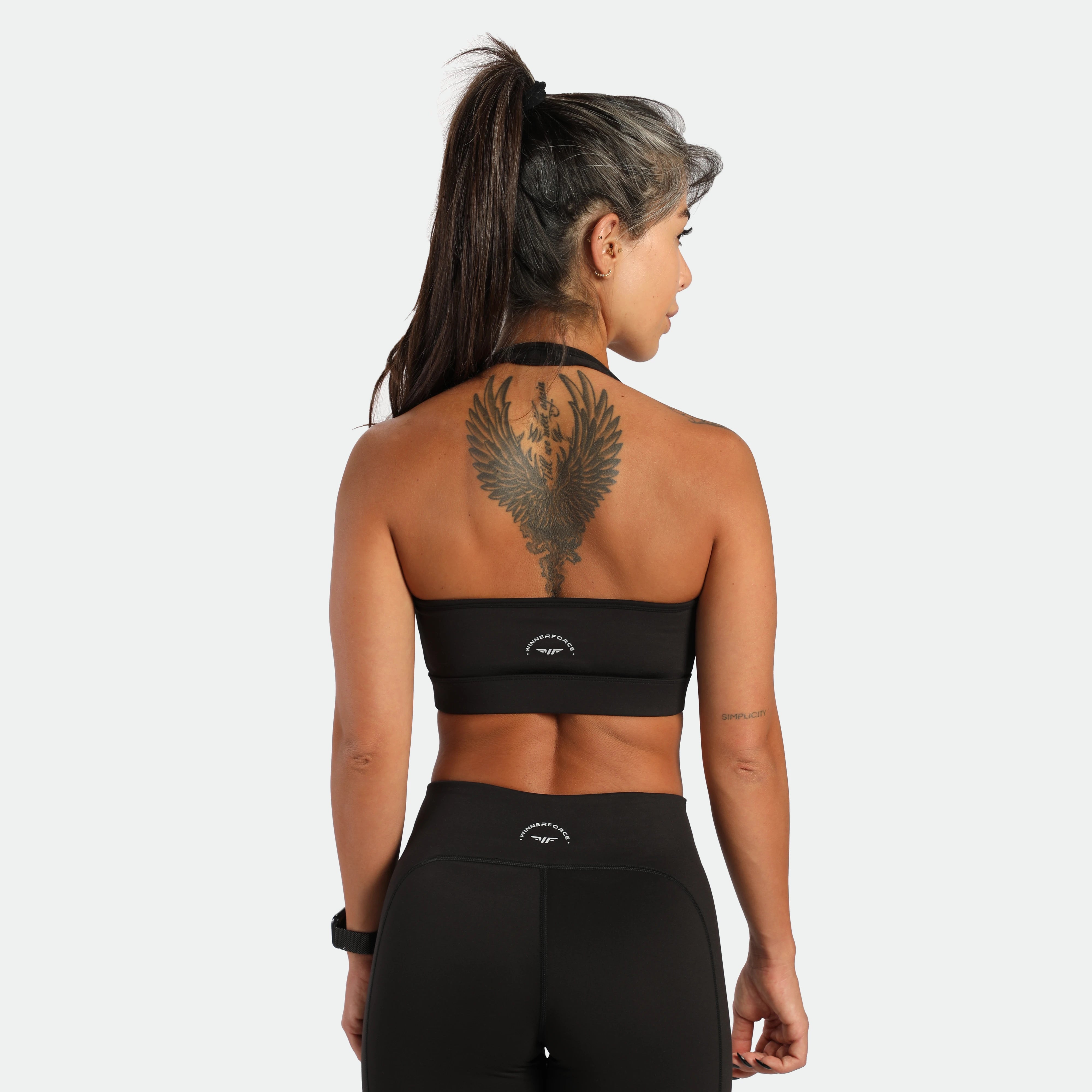 a back view for fit woman wearing matching set black ,bra an short ,plus the logo 