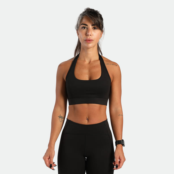 a fit woman look at the camera and she wearing matching set black ,bra and legging 