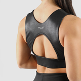 Back view of a woman wearing a faux leather bra and leggings, along with the logo and a light gray background