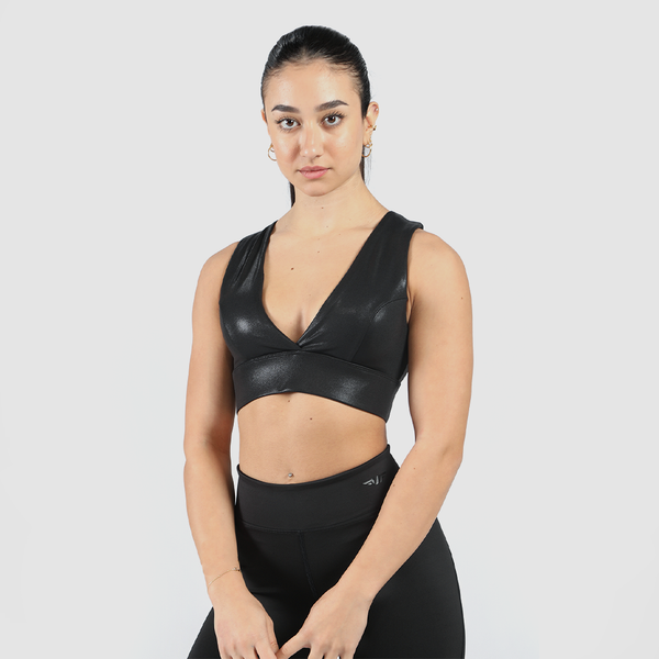 a woman wearing  a bra  and legging  black ,with special design for bra ,the background is light grey