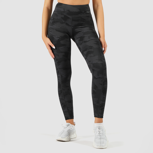 a woman wearing camo legging with  logo grey, and she wearing  shoes white ,the  background is light grey  