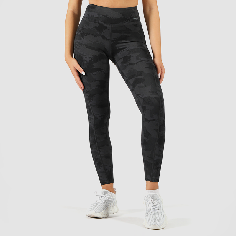 a woman wearing camo legging with  logo grey, and she wearing  shoes white ,the  background is light grey  