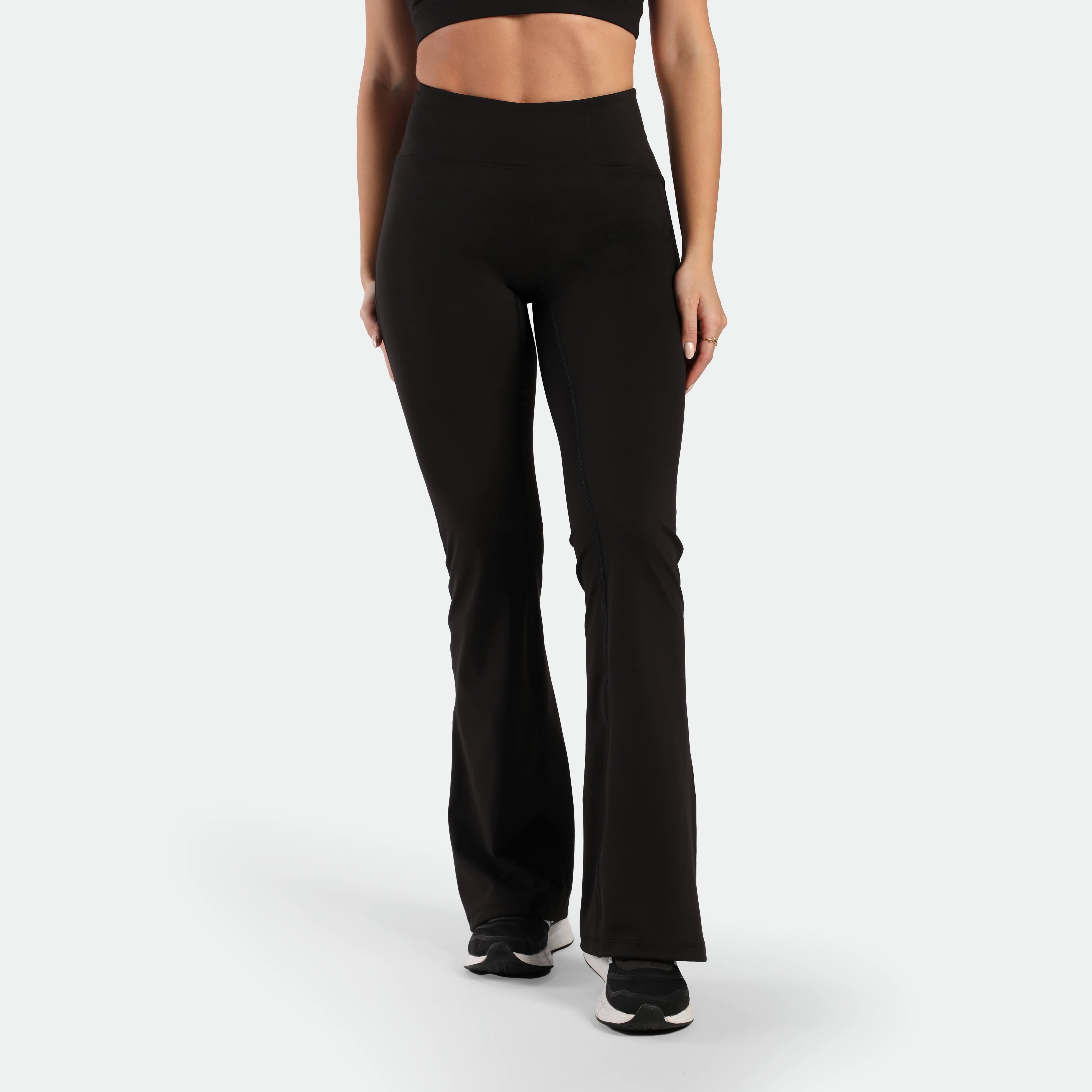 a fit woman wearing matching set black ,bra and flared legging , plus the shoes 