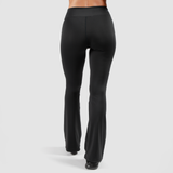 a back view for woman  wearing flared legging with shoes black ,the background is light grey