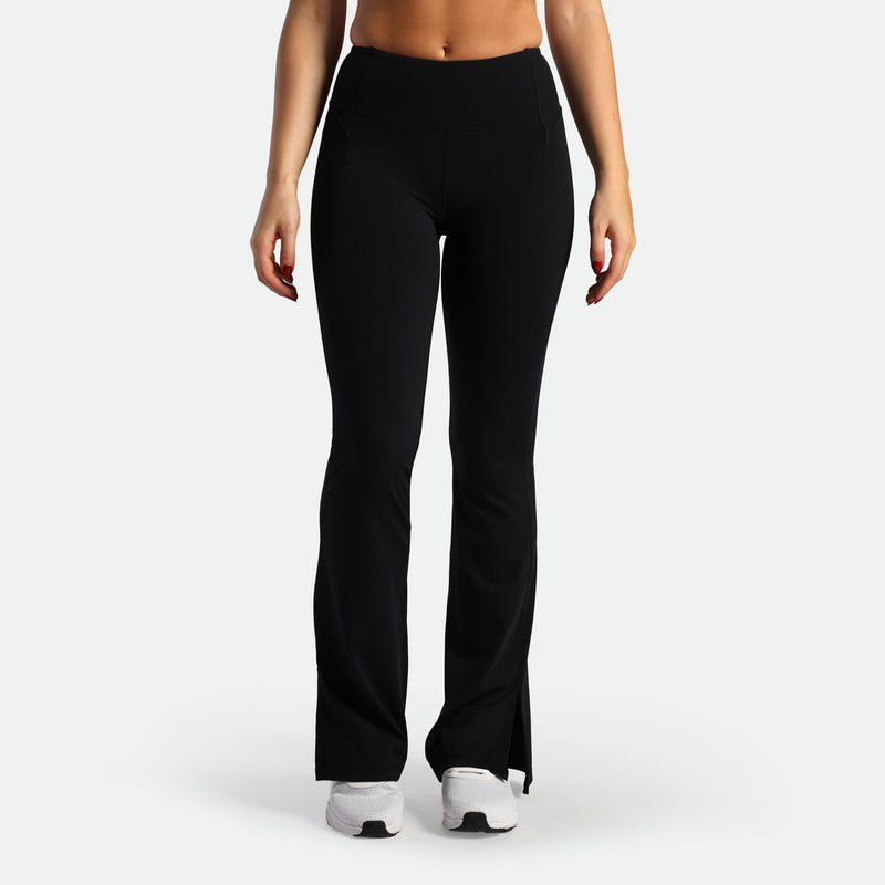 a fit woman wearing flared legging black with shoes white 