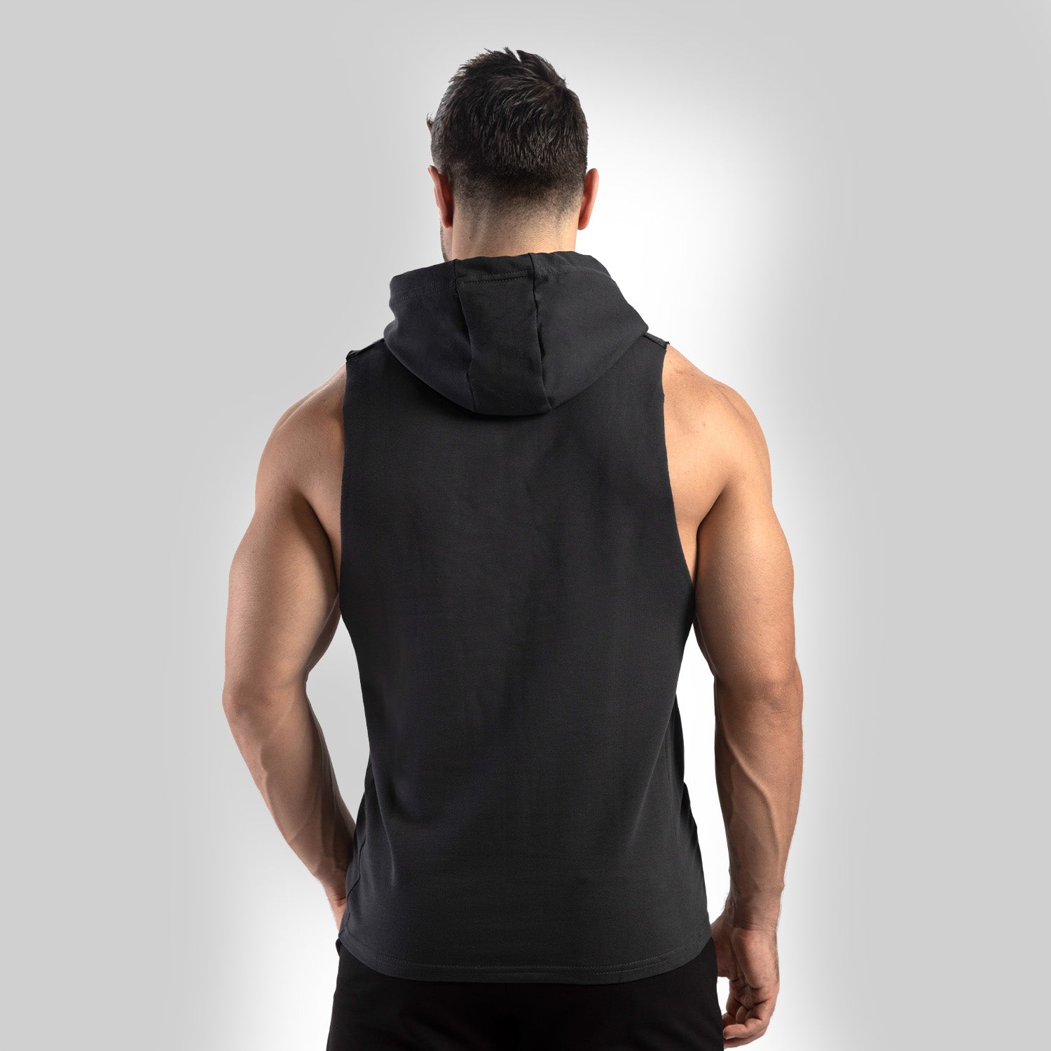 a back view for fit man wearing half hoodie  shadow black with pants black 