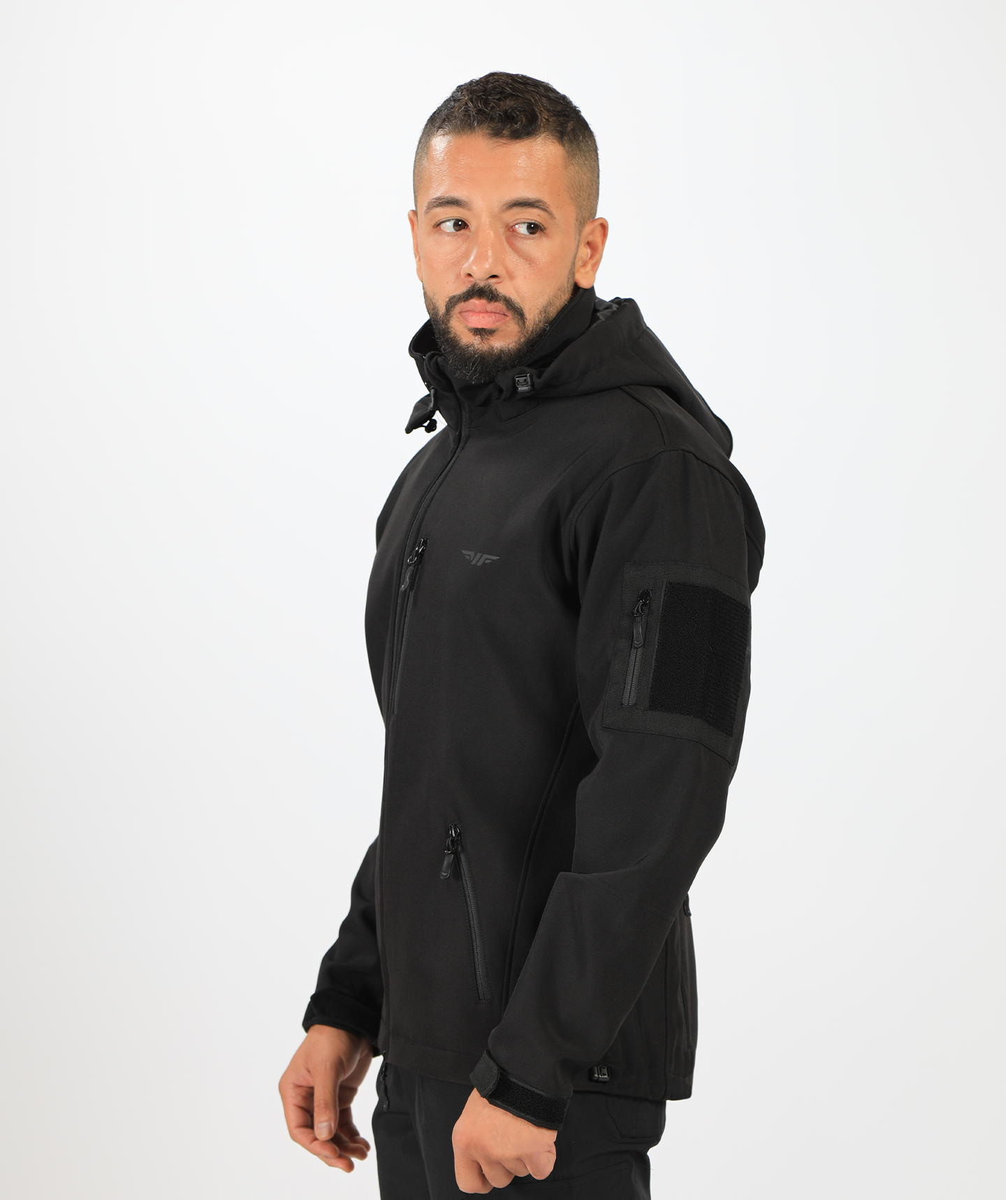 a fit man stand at right and wearing a polo jacket  black ,with pants black 