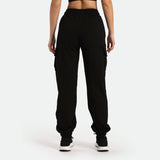 a back view for woman  wearing jogger pant and shoes black the background is light grey 