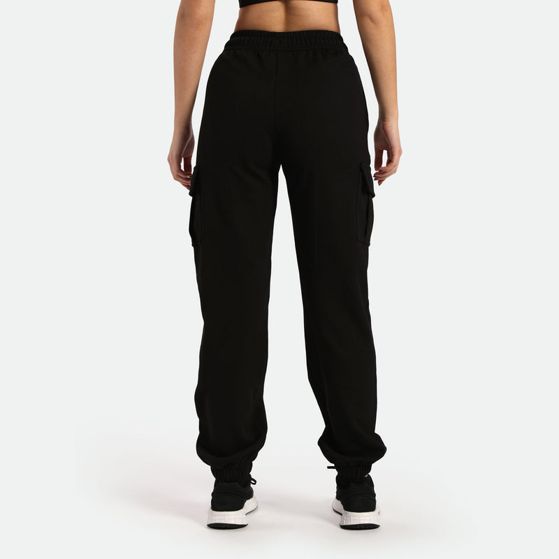 a back view for woman  wearing jogger pant and shoes black the background is light grey 