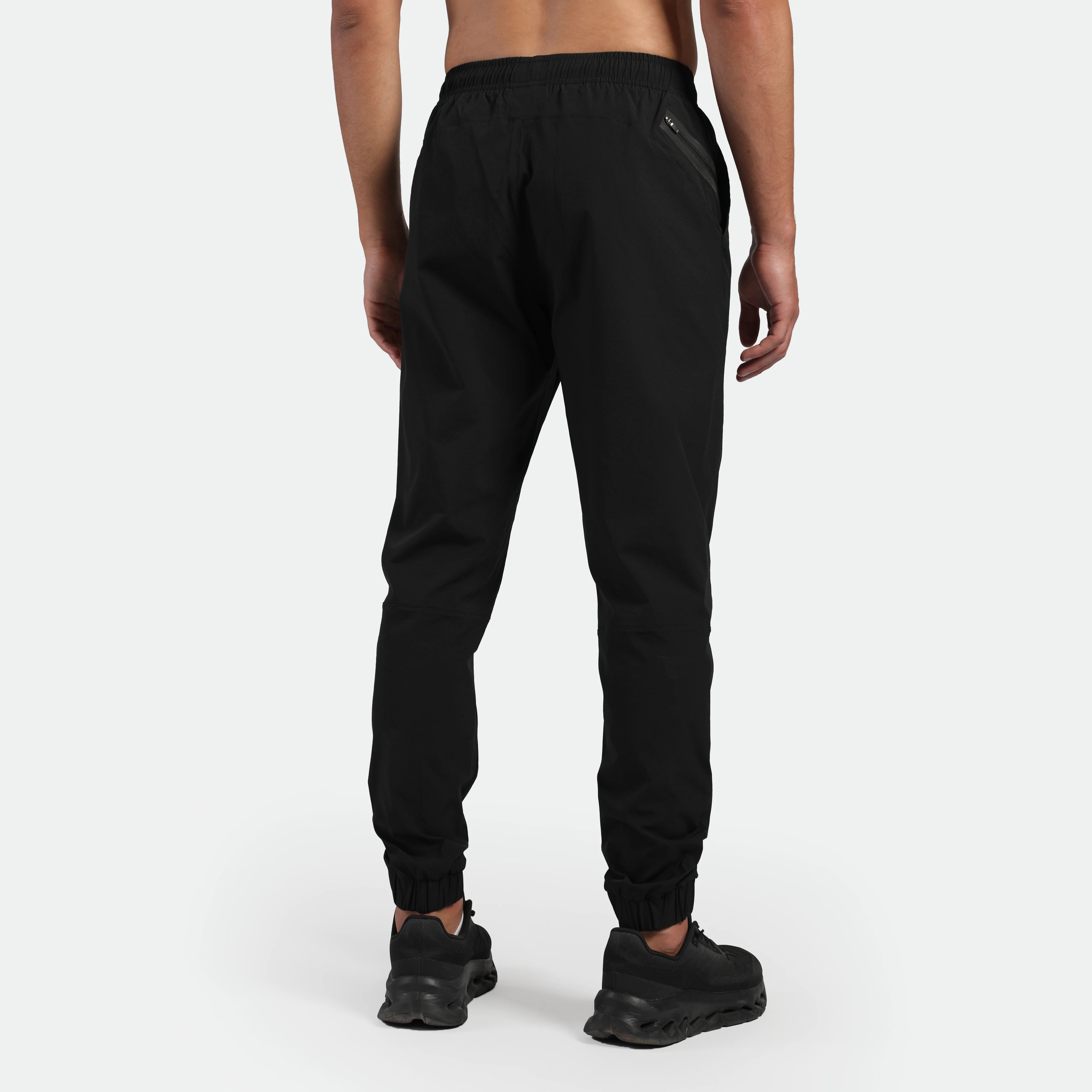 a back view  for fit man wearing jogger pants black with shoes 