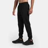 a fit man stand at right and wearing pants black with shoes  black 