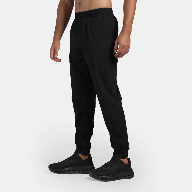 a fit man stand at right and wearing pants black with shoes  black 
