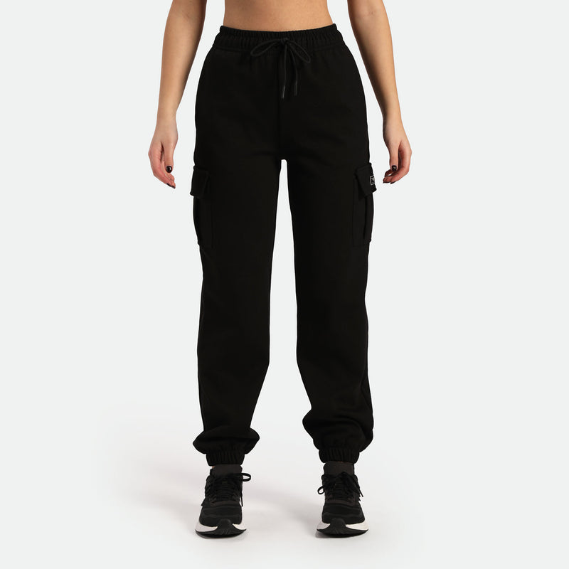 a woman wearing jogger pant with tow pocket and shoes same color is black ,plus the background is light grey 