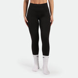 Person wearing black leggings and white socks on a white background