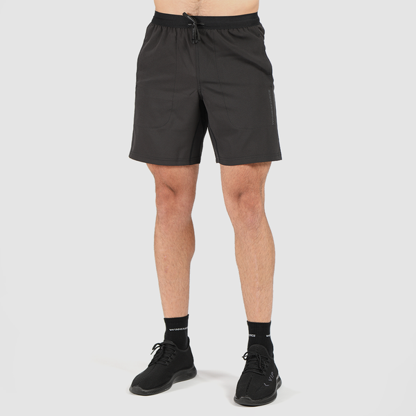 a fit man stand at right and wearing short black with shoes black and socks 