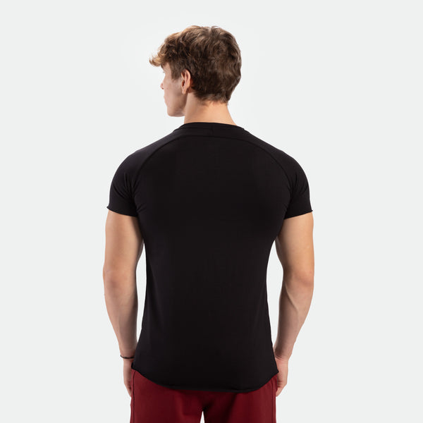 a back view for man wearing t-shirt  black with pants red 