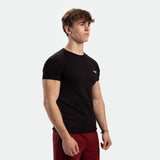 a fit man stand at right and wearing t-shirt  black with logo and pants red 