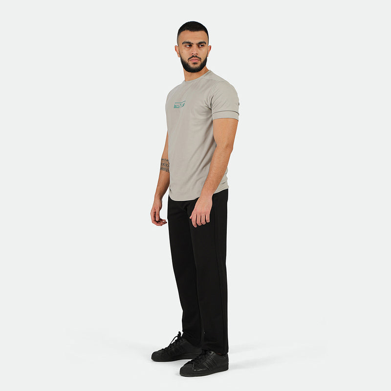 a fit man wearing t-shirt  grey with logo and pants black with shoes