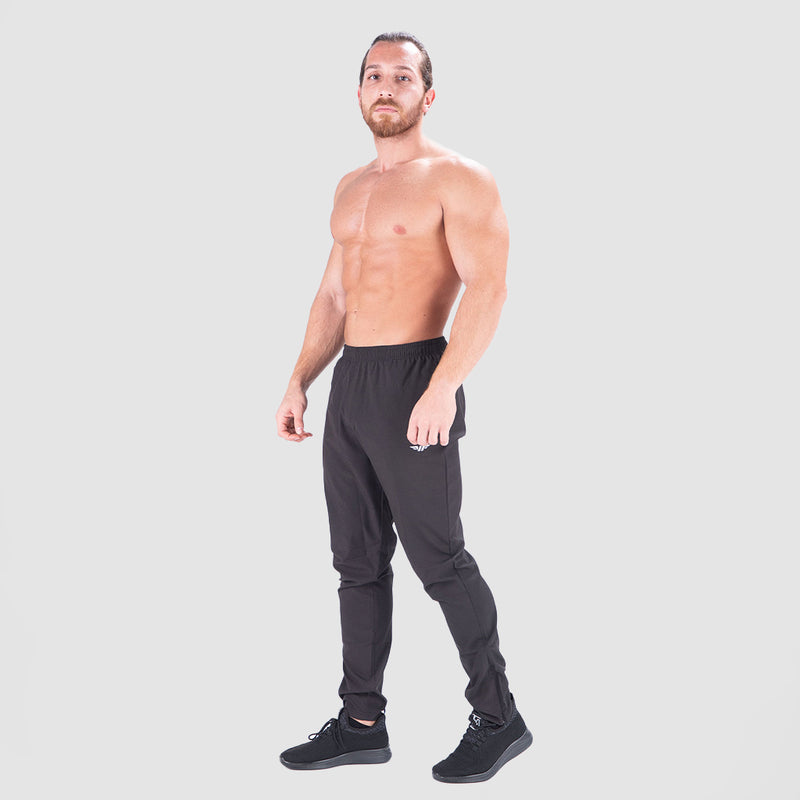 a fit man wearing  just pants  black with logo pus shoes black 