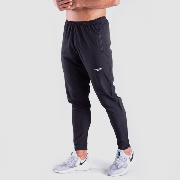a fit man stand at right and wearing pants black  with logo and shoes 