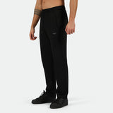 a fit man stand at right  and wearing  pants black with logo ,plus shoes black 
