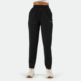 a fit woman wearing black  pants with shoes white ,plus the background is light grey 
