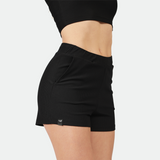 close up -view  for fit woman wearing black short ,plus the background is light grey 