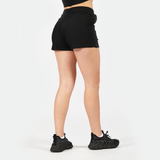 a back view for fit woman wearing short black and shoes black ,plus the background is light grey 