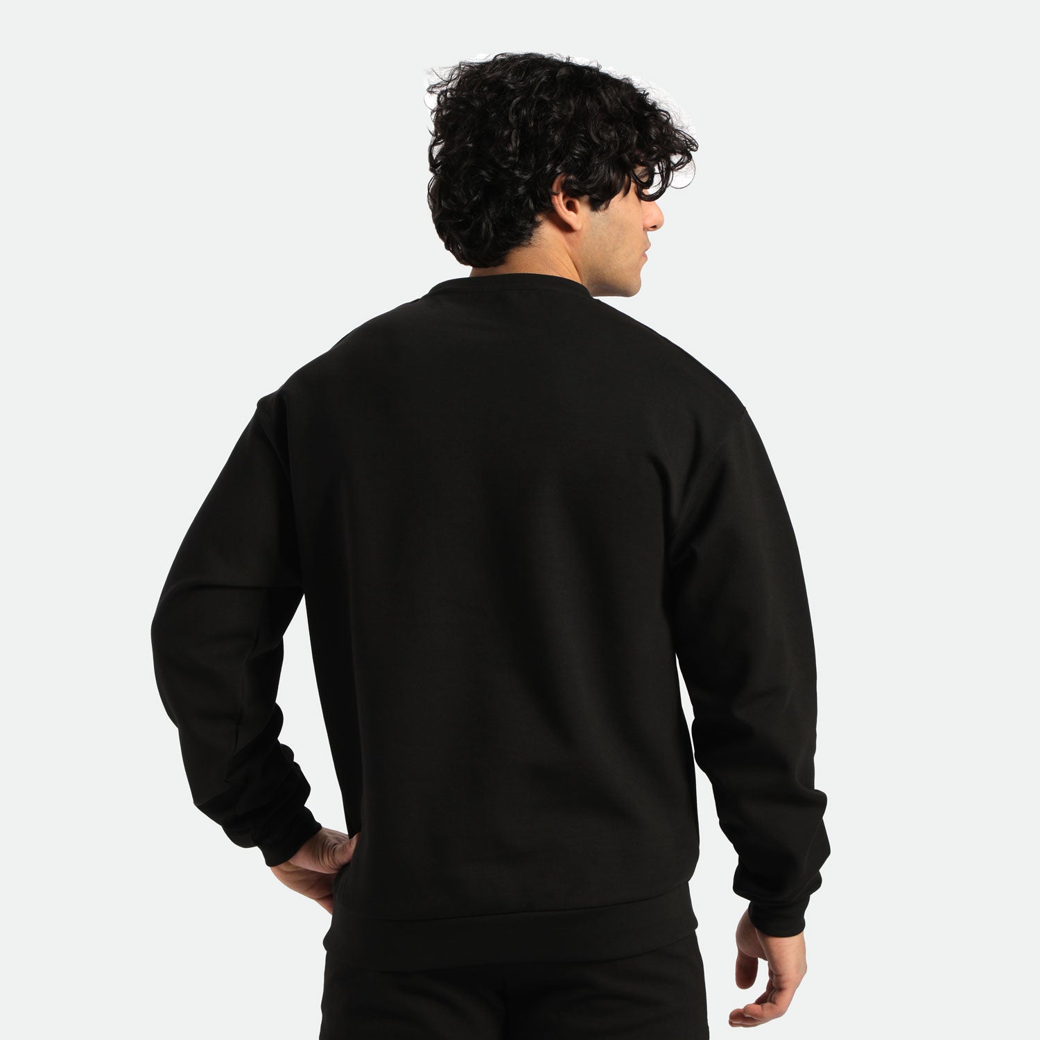 a back view for fit man wearing sweatshirt black with pants black 