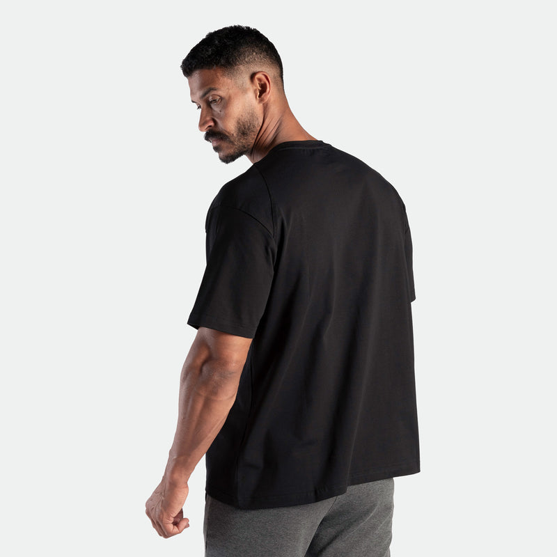 a back view for fit man wearing t-shirt black and pants grey 