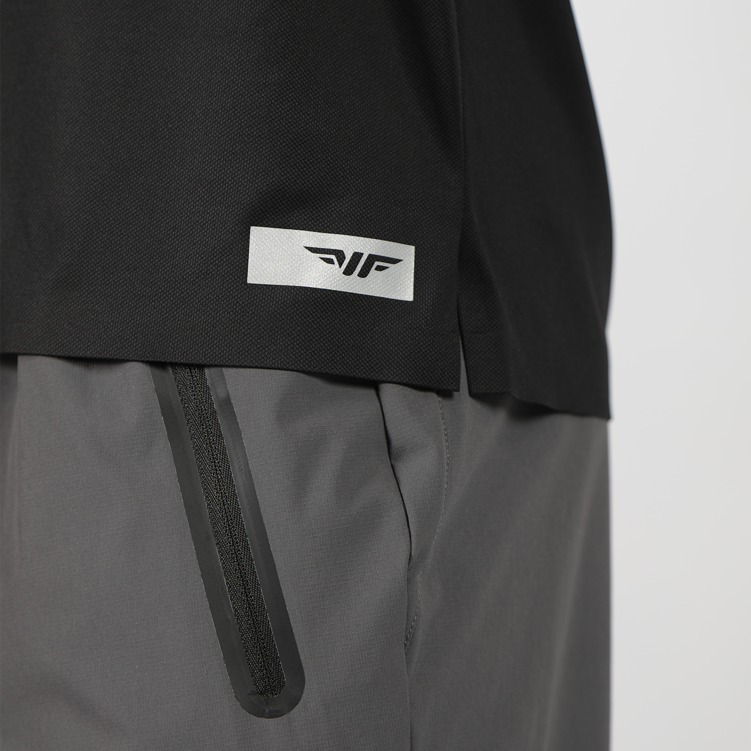 close up view of  logo for t-shirt black with zipper of pants grey 