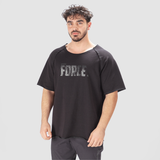A man wearing a black oversized t-shirt with the text 'FORCE' printed in large letters on the chest.