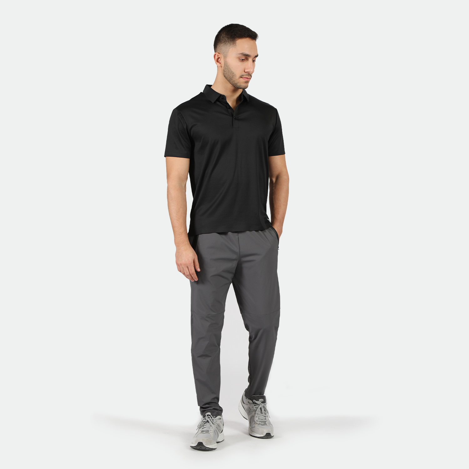 a fit man wearing t-shirt black  with pants grey ,plus the shoes 