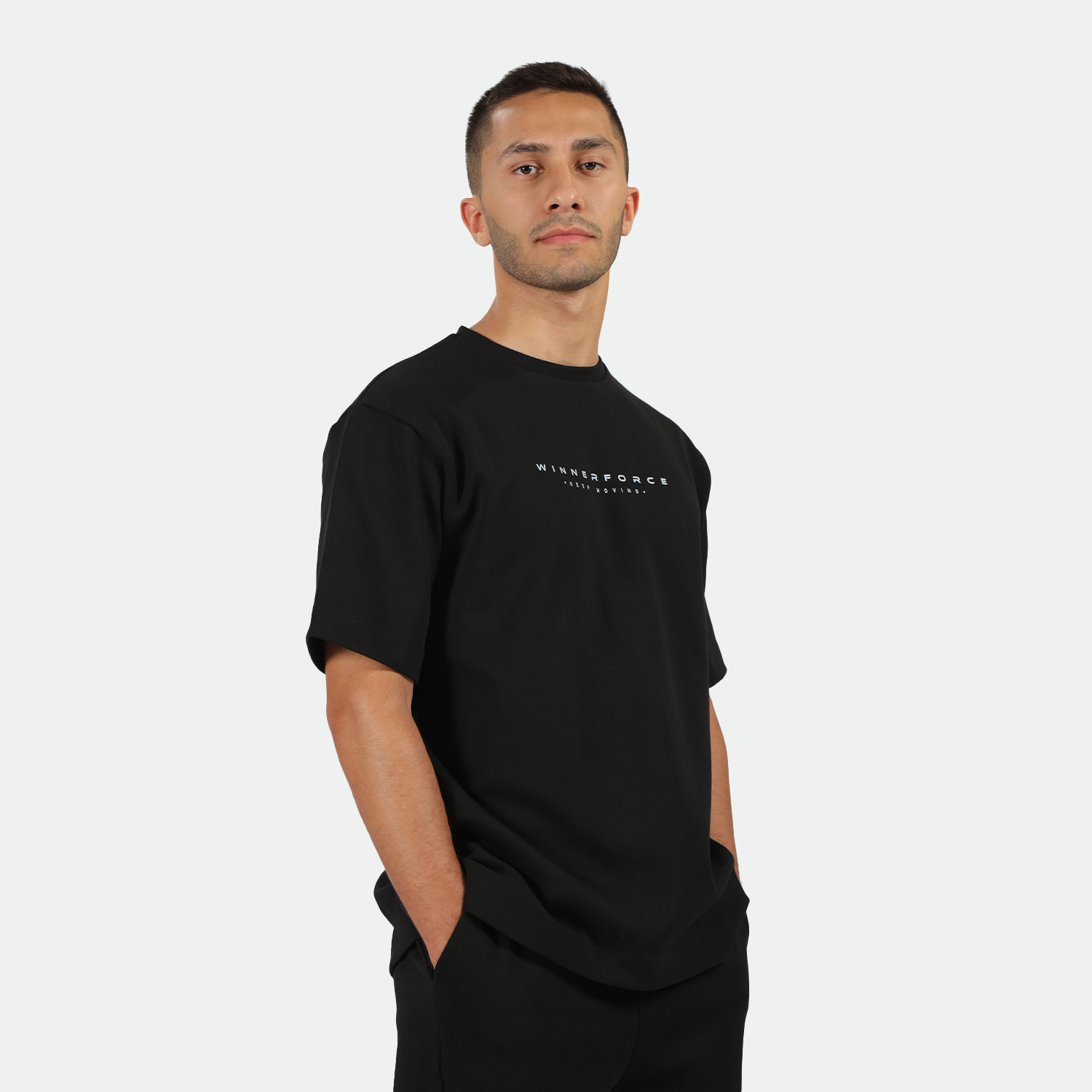 a fit man stand at right and wearing matching color set ,t-shirt and short 