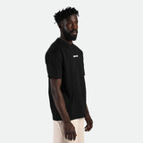 a fit man stand t right and wearing t-shirt black with short beige 