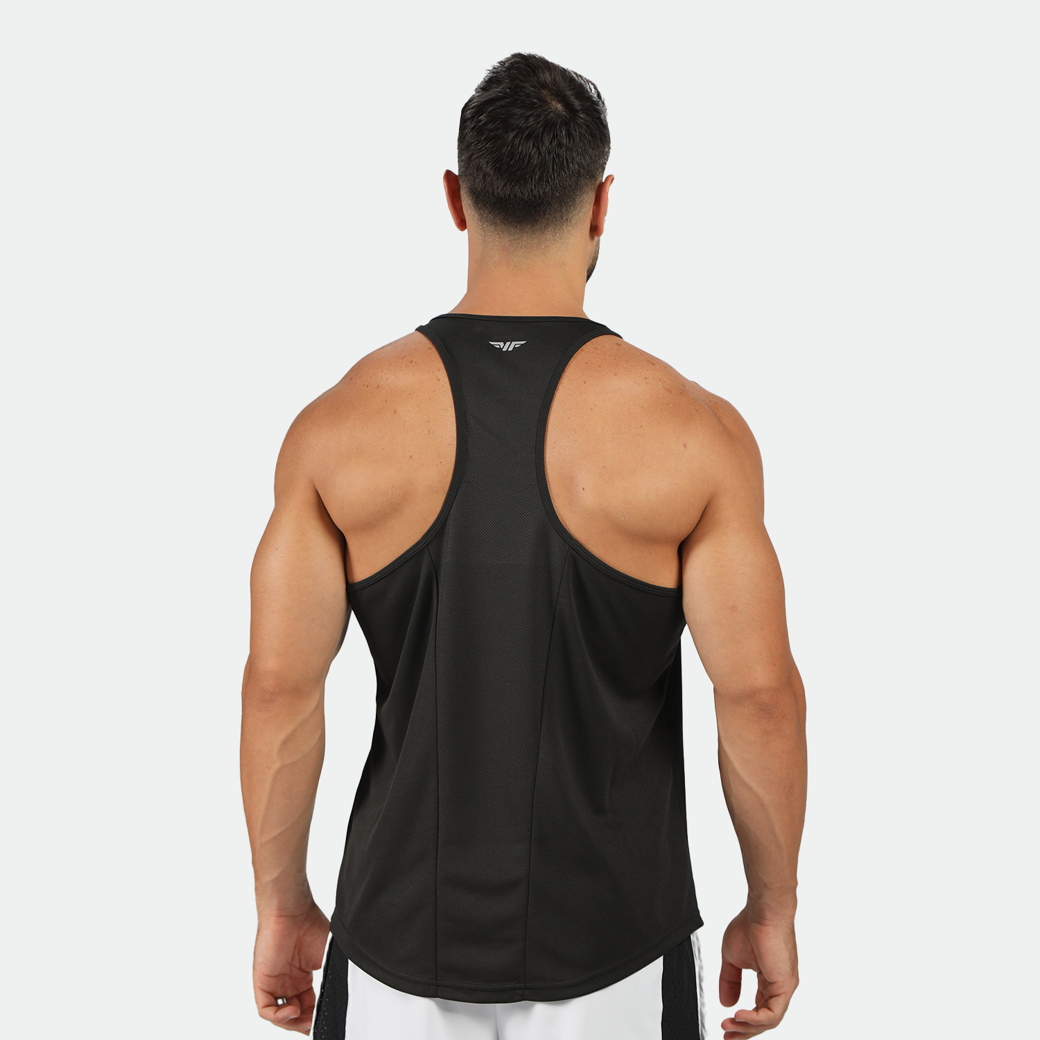 a back view for fit man wearing  tank black with pants light grey 