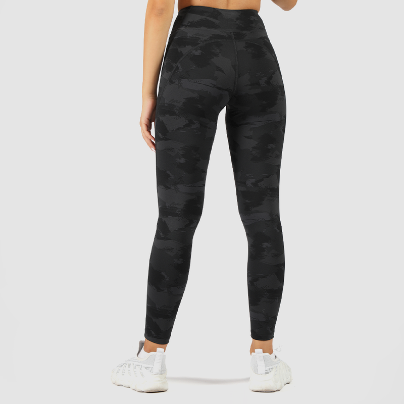 a back view for woman wearing camo legging  and shoes white ,the background is light grey