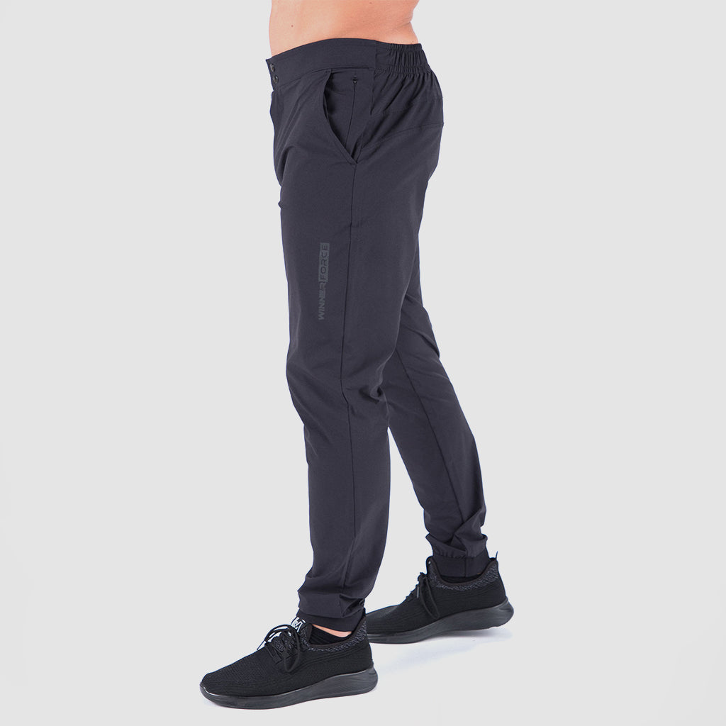 a fit man stand at right and wearing  pants black with shoes black 