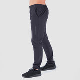 a fit man stand at right and wearing  pants black with shoes black 