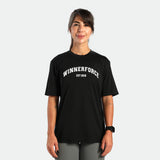 a fit woman stand with smile ,she wearing t-shirt black with short  sage  grey 