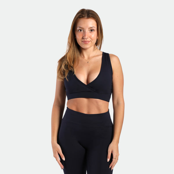 a fit woman wearing matching set navy blue ,bra and flared  legging 