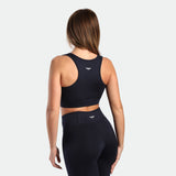 a back view for fit woman wearing  matching set navy blue ,bra and flared legging 