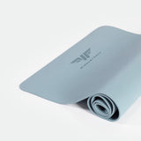 A rolled up blue training mat with a logo on the top surface, placed on a white background.