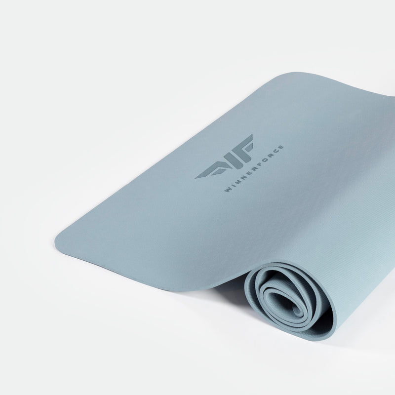 A rolled up blue training mat with a logo on the top surface, placed on a white background.