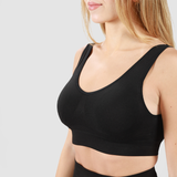 Woman wearing matching black bra and leggings with light gray background