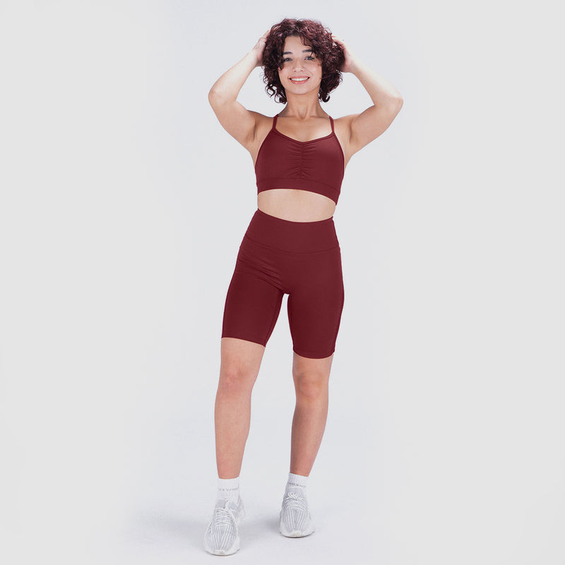 a women wearing matching  bra ad legging red ,she stand quarter   with background light grey