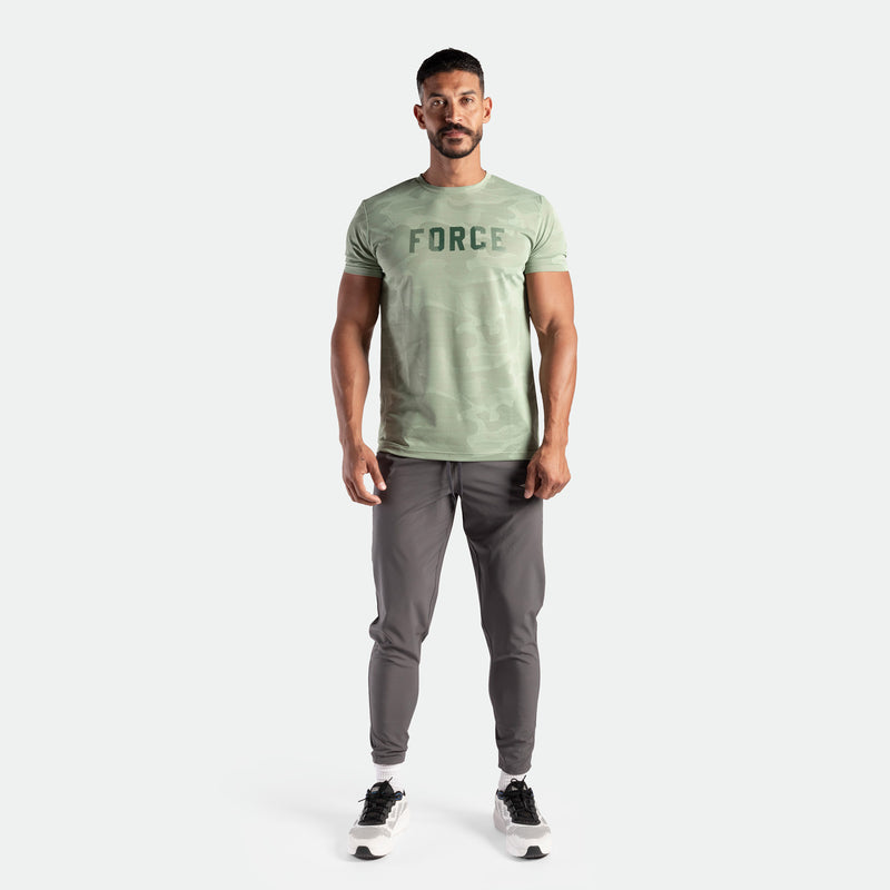 a fit man wearing t-shirt camo green by with logo and pants grey ,plus the shoes 